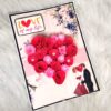 Quilled red flowers in heart greeting card